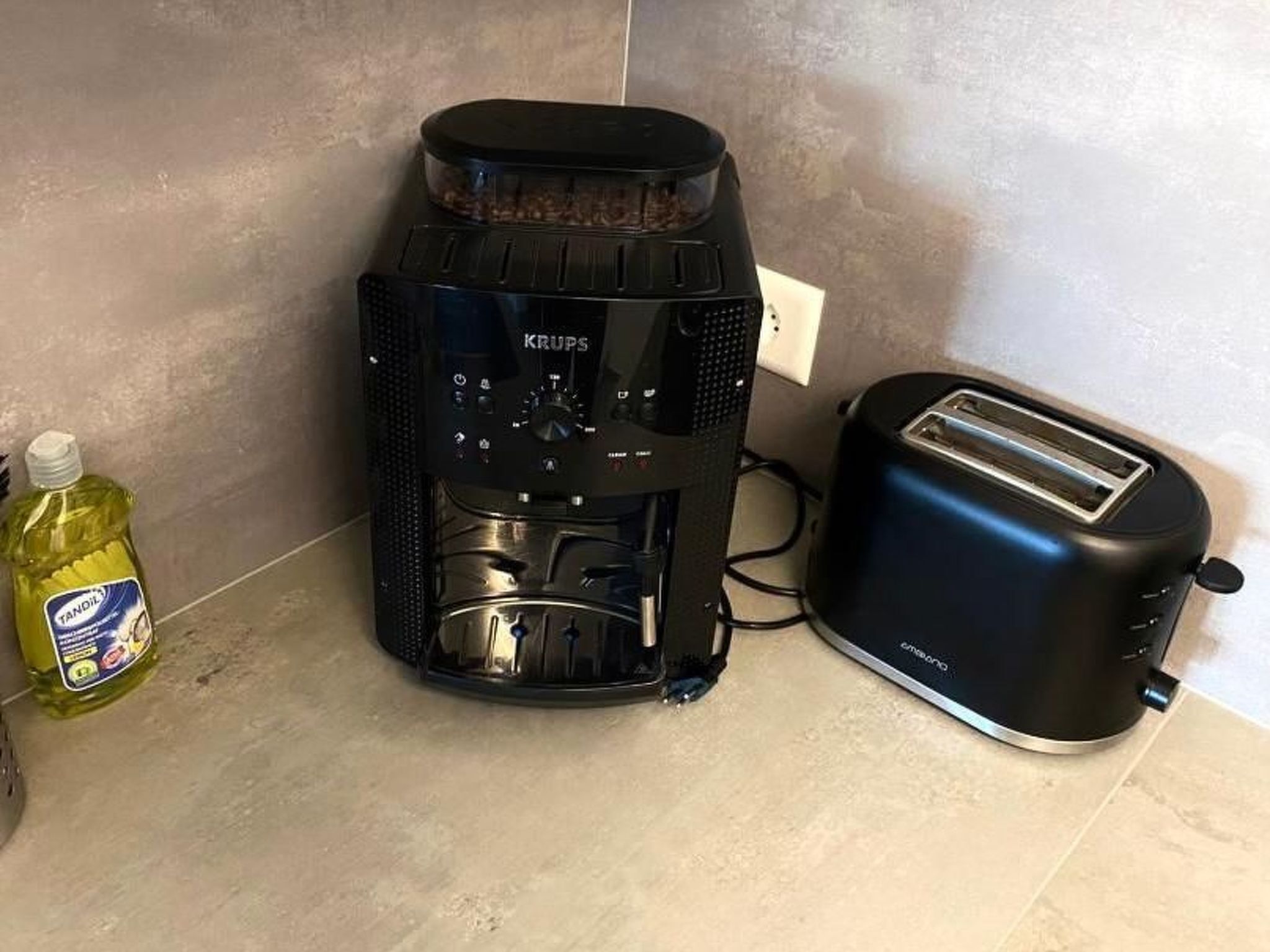 Eine Küche mit Kaffeemaschine, Toaster und einer Flasche Spülmittel.