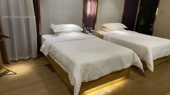 A hotel room with two single beds, a bedside table with a lamp, a mirror, and a curtain. - PCLJ Hotel Bao'an Centra (Shenzhen)