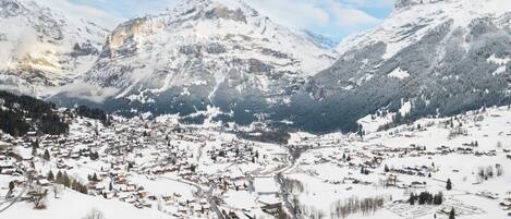 A snow-covered mountain town with a valley, buildings, and roads.
