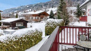 A snow-covered mountain landscape with a wooden cabin and a red-roofed building. - Kitzresidenz 11 von Alpinresort Kaprun by Interhome (Kaprun)