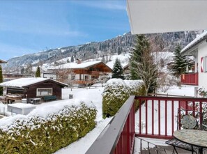 Eine verschneite Berglandschaft mit einer Holzhütte und einem Gebäude mit rotem Dach.