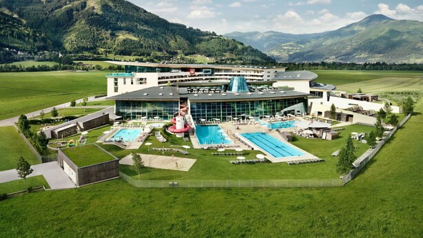 A modern hotel with multiple swimming pools, a water slide, and a mountain backdrop. - Alpinresort Kaprun top 2 by Interhome (Kaprun)