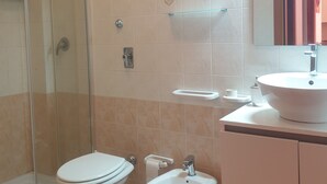 Ein Badezimmer mit Toilette, Bidet und einer Duschkabine.