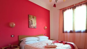Ein Schlafzimmer mit einem Bett, einem Nachttisch und einem Gemälde an der Wand.