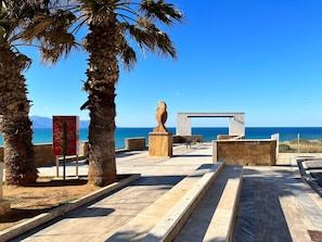 A coastal promenade with palm trees, a sculpture, and a view of the sea. - Wohnung in Balestrate mit Schwimmbad und Meerblick by Interhome (Balestrate)