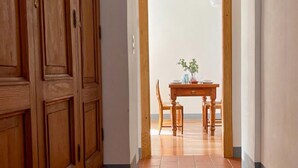 A hallway with wooden doors and a dining area with a table and chairs. - Chalet Bazzi by Interhome (Brissago)