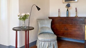 A corner with a round table, a chair, a floor lamp, a dresser, and a framed picture on the wall. - Chalet Bazzi by Interhome (Brissago)