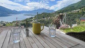 Ein Holztisch mit einer gelben Tasse, zwei Gläsern und einem kleinen Topfpflanzen.
