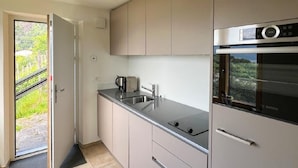 Eine moderne Küche mit Backofen von Bosch, Edelstahlarbeitsplatten und hellen Schränken.