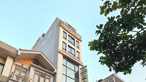 A hotel with a prominent sign, a balcony, and a storefront with a sign for a pocket billiards club. - HEYI HOTEL (Tu Son)