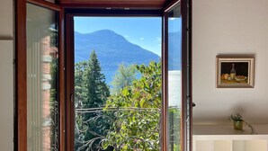 Varanda aberta com vista para uma montanha e árvores.