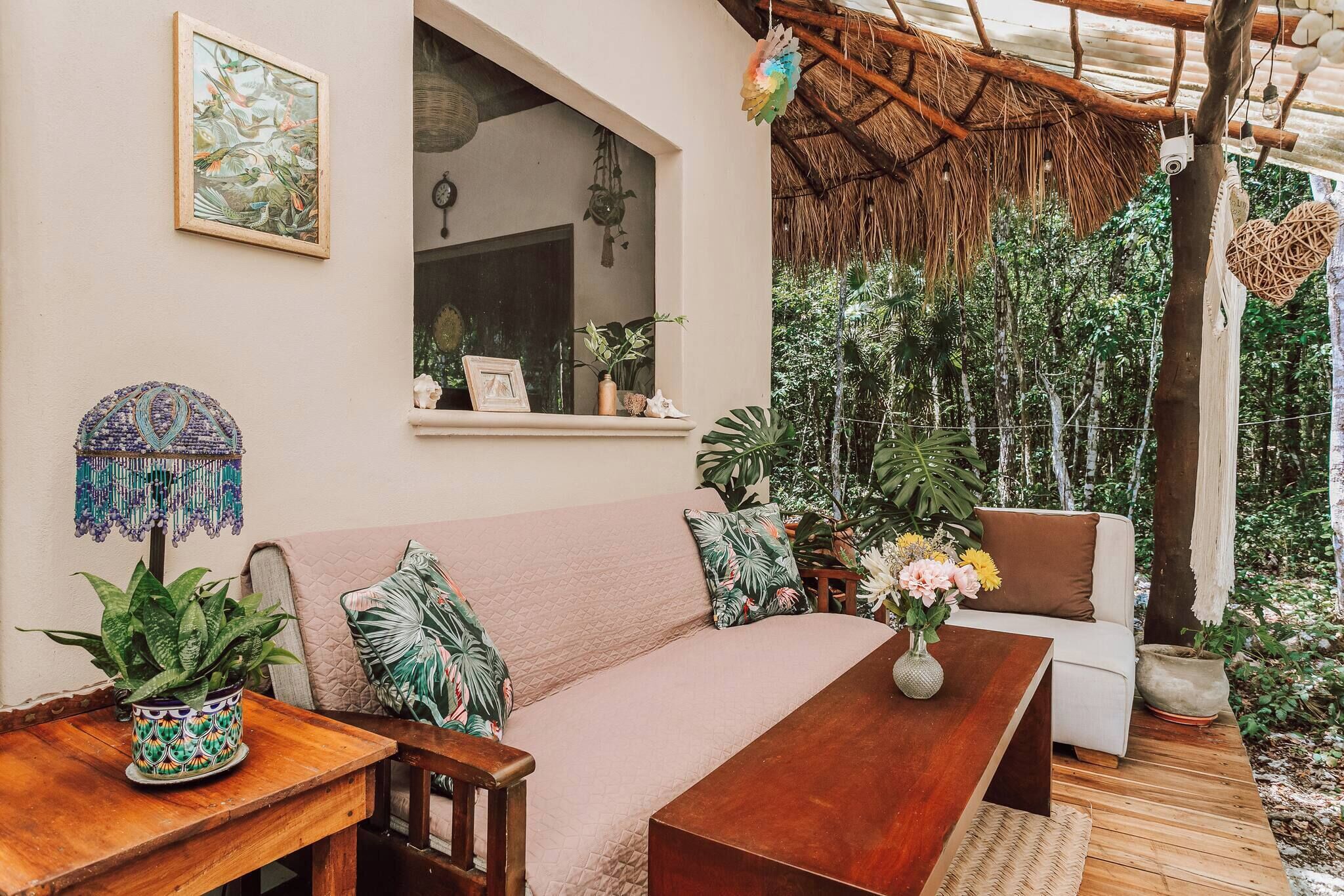 Un salón acogedor y bien decorado con un sofá, una mesa de madera y varias plantas.