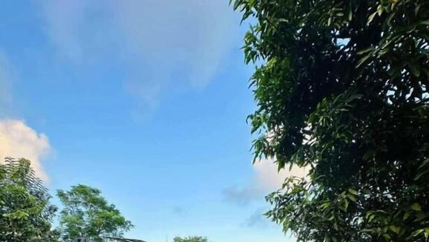 Un quartier résidentiel doté d’une piscine, d’un petit pont et d’un sentier menant à une maison avec un toit rouge.