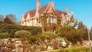 A large, historic building with a prominent stone facade and multiple chimneys. - Cosy one bedroom flat in a country house. (Bromham)