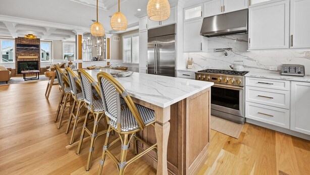 A modern kitchen with white cabinetry, stainless steel appliances, and a central island with seating. - Summer House - Luxury 5BR w/ Heated Pool Near Beach (Ocean City)