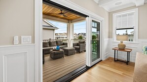 A spacious balcony with wicker furniture and a view of neighboring houses. - Summer House - Luxury 5BR w/ Heated Pool Near Beach (Ocean City)
