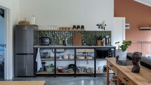 Eine moderne Küche mit Einbau-Mikrowelle, Kühlschrank und einer Holz Arbeitsplatte.
