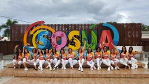 A group of people posing in front of a colorful sign with the word "COSINA" on a wooden platform. - Casa Linda Beautiful Villa (Sosúa)