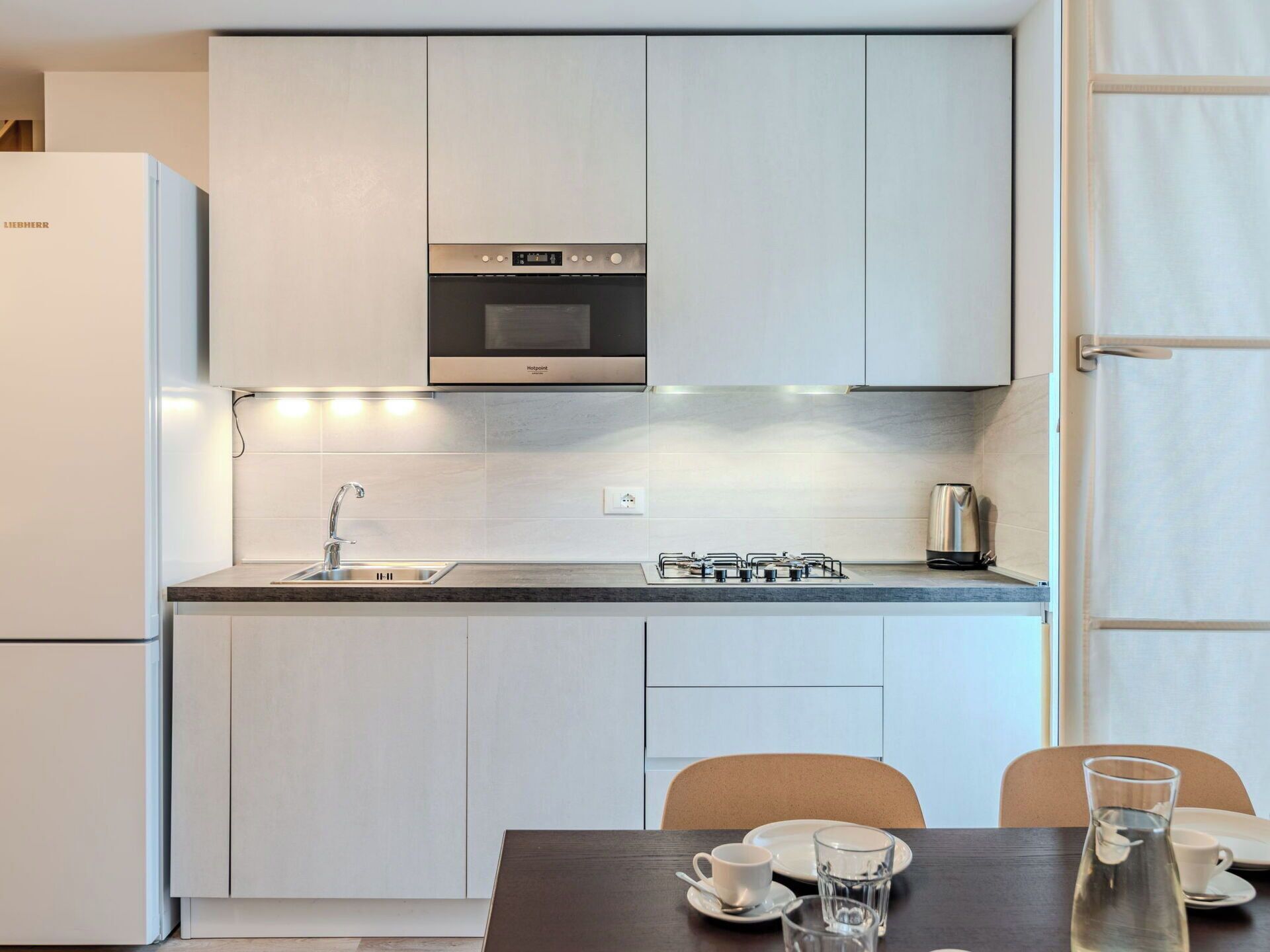 A compact kitchen with a built-in oven, a gas stove, and a sink.