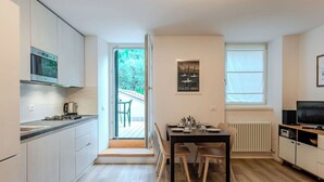 Une cuisine moderne avec un coin repas, une vue sur l’extérieur et un téléviseur.