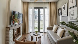 Un salon avec une cheminée, un canapé, une table basse et un ventilateur de plafond.
