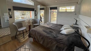 A bedroom with a large bed, a chair, a desk, and a window. - 5 Star Holiday Home in Skummeslovsstrand (Skummesloevsstrand)