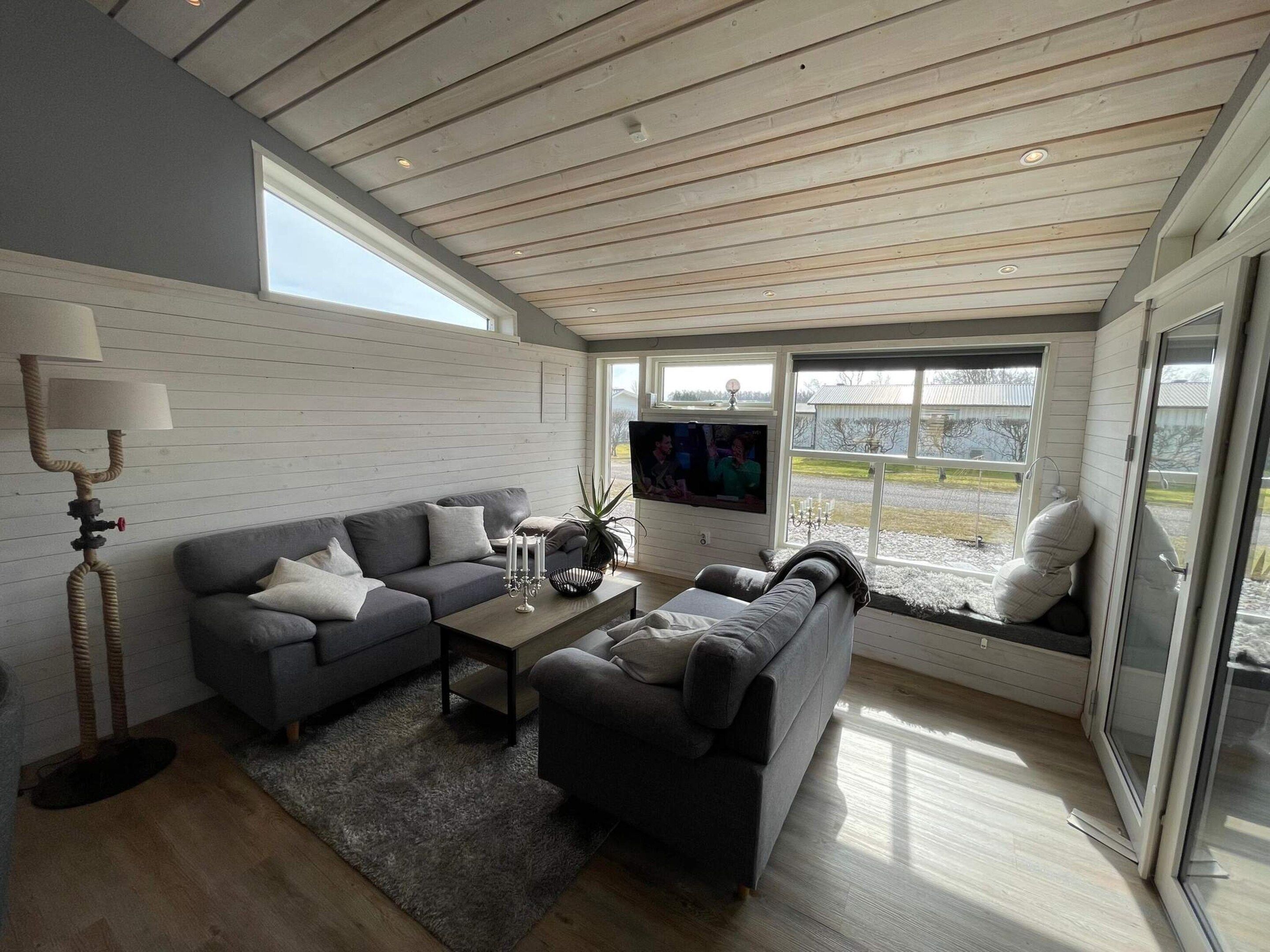 A modern living room with a grey sofa, a coffee table, and a TV.
