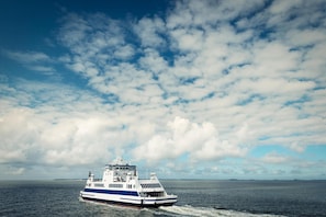 A ferry boat on a body of water with a partly cloudy sky. - The View B10 AHOI - Sea view, balcony, 2nd floor, shared. (Dagebüll)