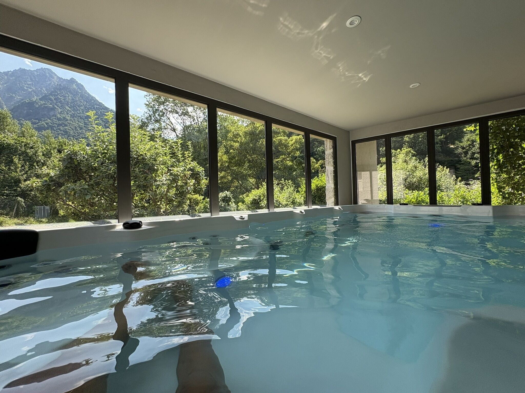 Ein Schwimmbad mit großen Fenstern und Bergblick.