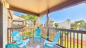 A balcony with wooden railings and three turquoise Adirondack chairs. - Portside Paradise SC4-Steps to Beach-Sleeps 5 (Panama City Beach)