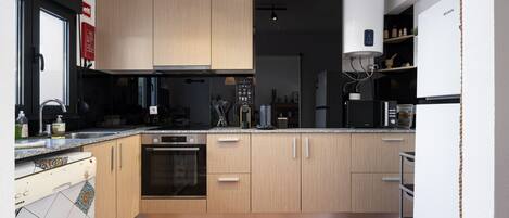 A modern kitchen with wooden cabinets, a built-in oven, and a dishwasher.
