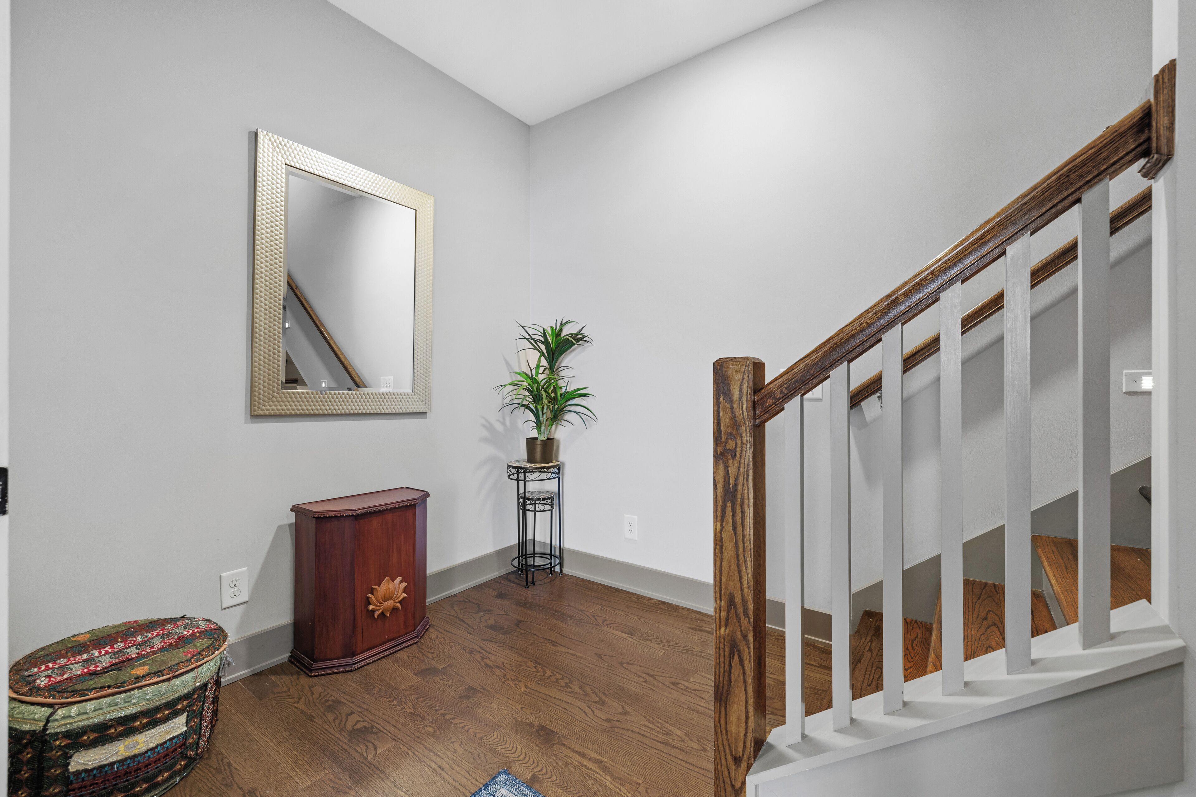 Una escalera con barandillas de madera y una pared blanca.