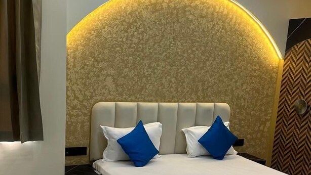Ein modernes Schlafzimmer mit einem großen Bett, zwei Kissen, einem Kopfende mit geschwungener Form und einem Marmorboden.