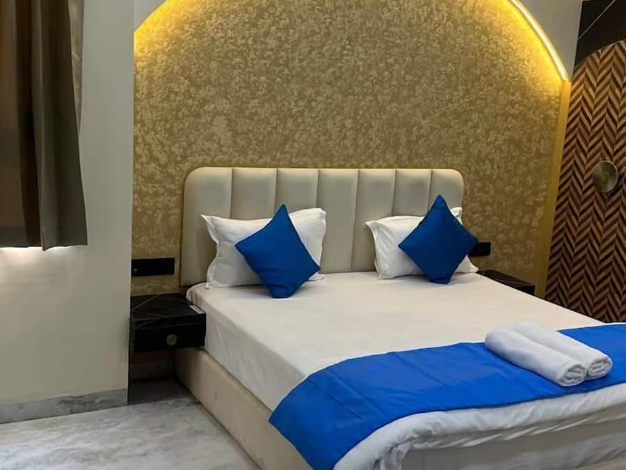 Un dormitorio moderno con una cama grande, dos almohadas, cabecera de diseño curvo y suelo de mármol.