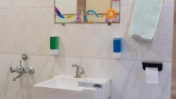 A bathroom with a white sink, a mirror, a towel rack, and a toilet.