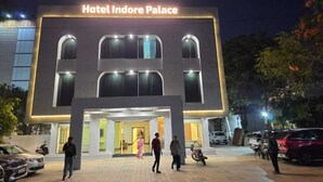 Hotel Indore Palace mit moderner Fassade, großen Fenstern und einladendem Eingang.