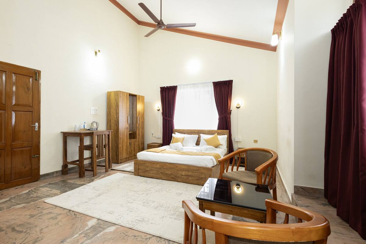 A bedroom with a bed, wooden furniture, a ceiling fan, and a nightstand.