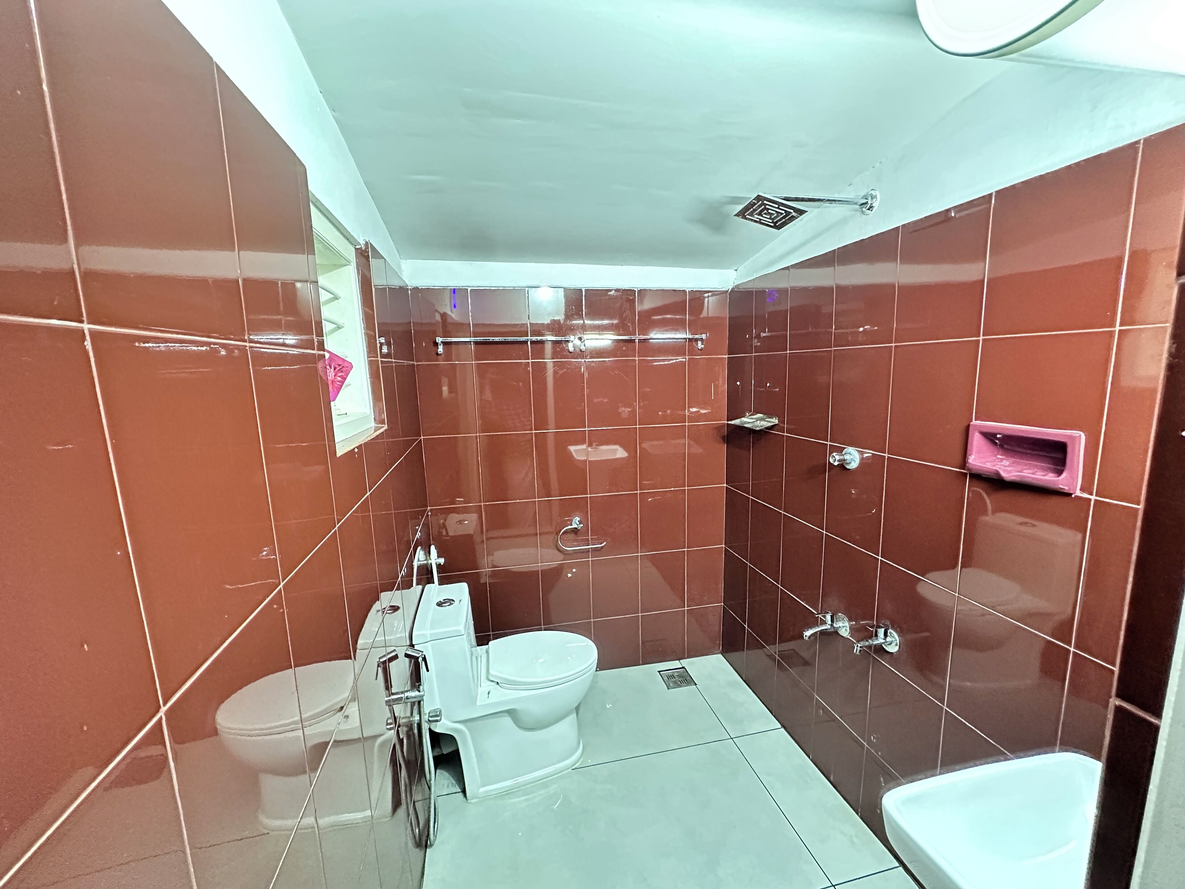 A compact bathroom with a toilet, bidet, and sink.