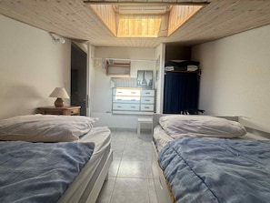Ein Schlafzimmer mit zwei Betten, einem Schreibtisch und einem Kleiderschrank.