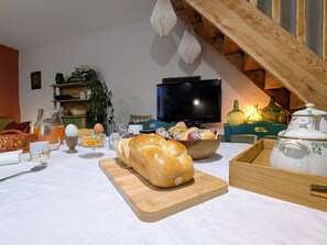 Une table à manger avec du pain, un bol et divers ustensiles de cuisine.