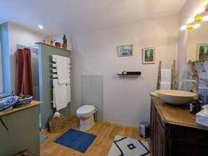 Un baño pequeño con inodoro, lavamanos y zona de ducha.