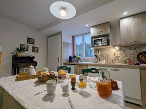 Une cuisine moderne avec une table à manger dressée pour le petit-déjeuner, un four à micro-ondes et une fenêtre offrant une belle vue.