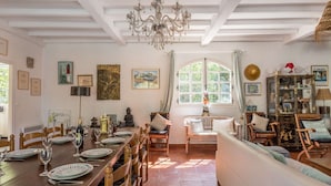 Una sala da pranzo con un tavolo in legno apparecchiato per un pasto, una statua di Buddha e un lampadario.