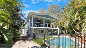 A two-story house with a pool, surrounded by tropical vegetation. - The Palms - Beach Retreat With Pool, Garden, BBQ (Toogoom)