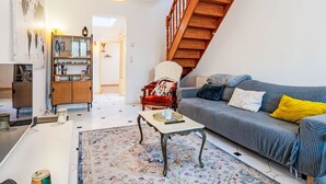 Ein modernes Wohnzimmer mit Treppe, Sofa, Couchtisch und Bücherregal.