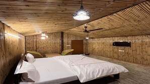 Ein Zimmer mit einem Bett, einem Deckenventilator und einer Hängelampe.