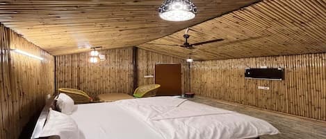 Una habitación con cama, ventilador de techo e iluminación colgante.