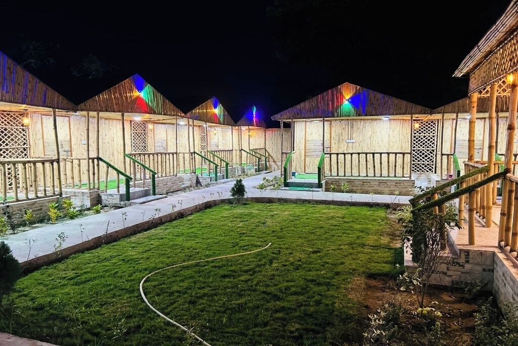 A series of wooden buildings with a central grassy courtyard, surrounded by pathways and staircases.
