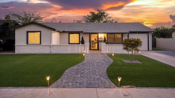 A modern two-story house with a brick pathway leading to the entrance, surrounded by well-maintained lawns and a tree. - Chic Home With Backyard Oasis Pool Game Room (Phoenix)