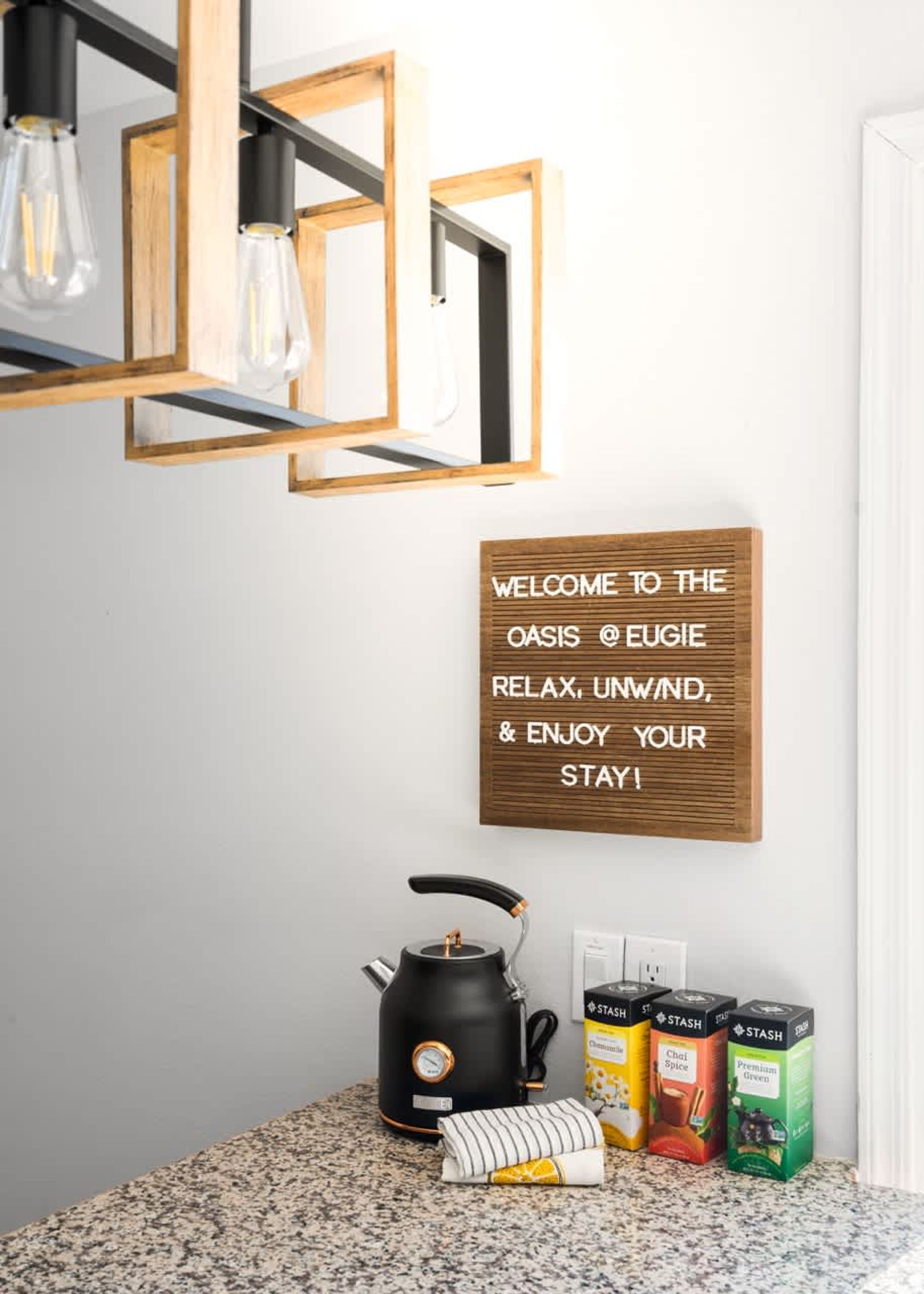 Ein Küchenbereich mit Kaffeemaschine, Tee und einem Willkommensschild.